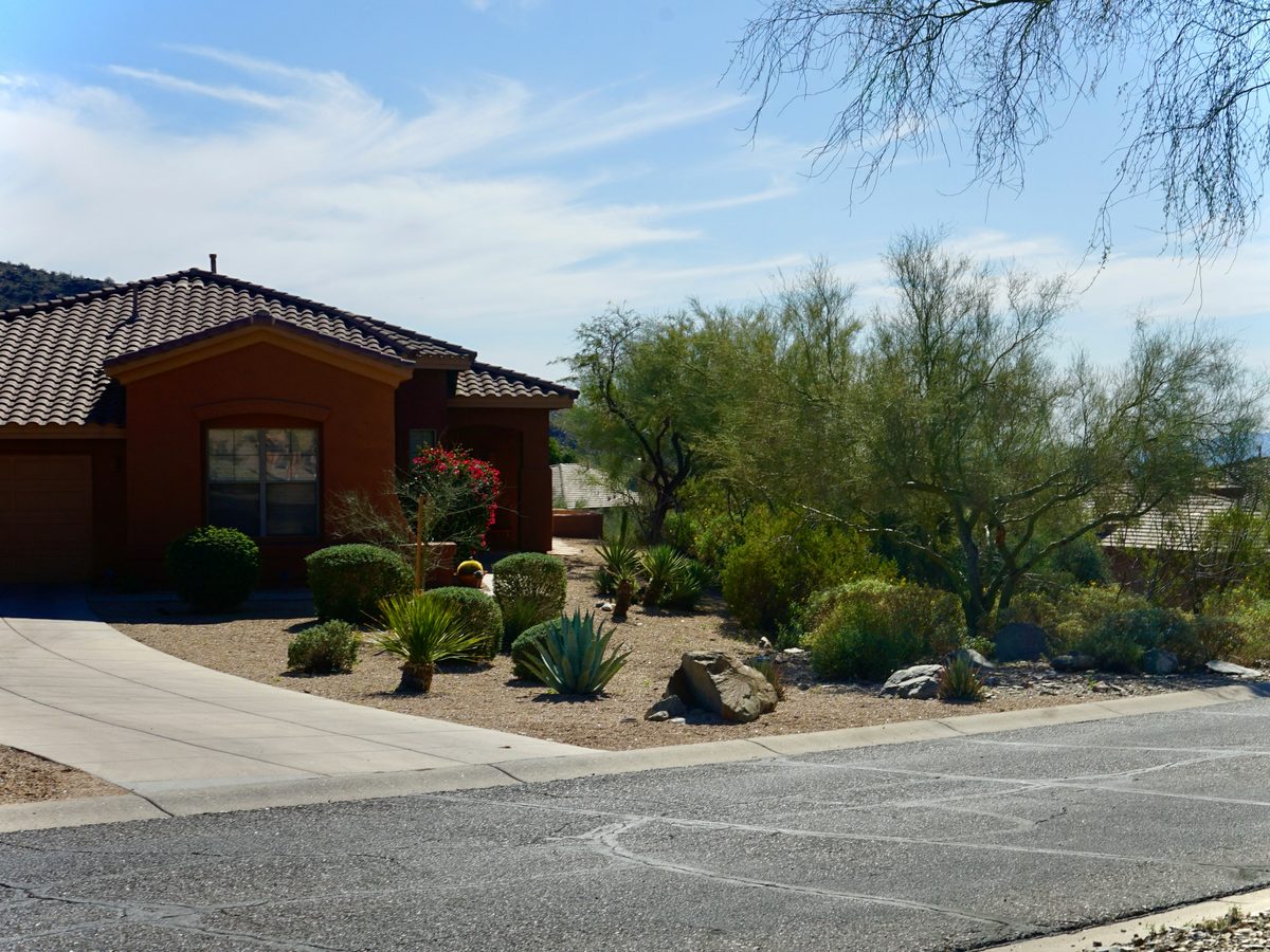 A single story home with gravel and low drought tolerant planting kept clear of the walls