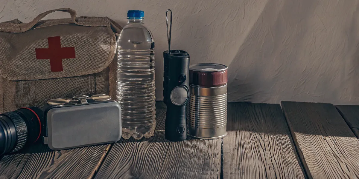 Wildfire emergency kit with first aid, water, flashlight, food, and essential gear.