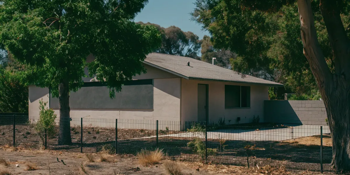 House in dry brush, illustrating wildfire insurance risk.
