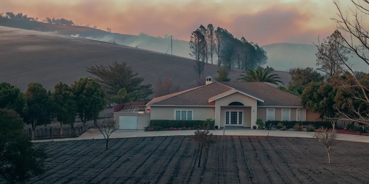 Home protected by wildfire prevention stands amid scorched land in Northern California.