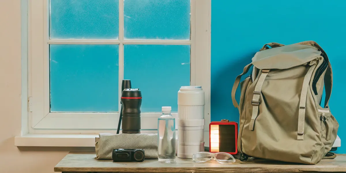 A wildfire emergency supply kit packed in a go-bag with water, a flashlight, and safety goggles.