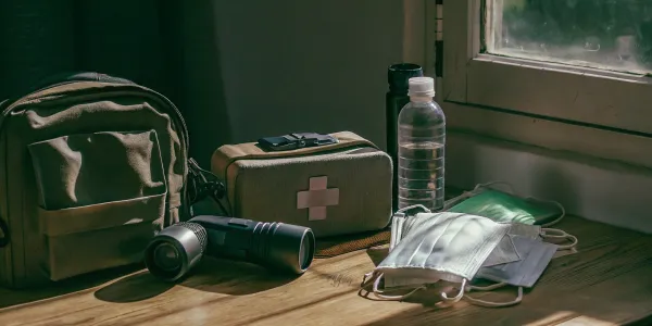Wildfire emergency kit essentials: water, first aid, flashlight, and N95 masks.