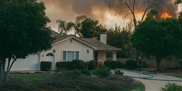 A home threatened by a wildfire highlights the critical need for wildfire prevention.