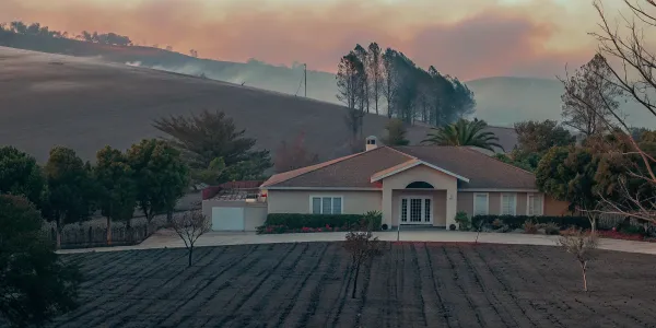 Home protected by wildfire prevention stands amid scorched land in Northern California.