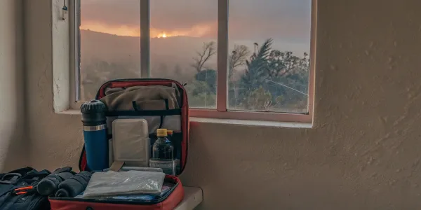 A Northern California wildfire go bag packed and ready for evacuation as a fire burns outside.