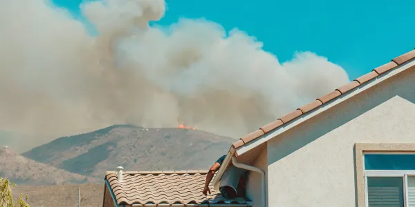 A home threatened by wildfire, a key reason for homeowners to have wildfire insurance coverage.