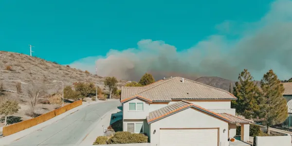 Wildfire risk evaluation for a home near a smoky hillside, a key report for insurance coverage.